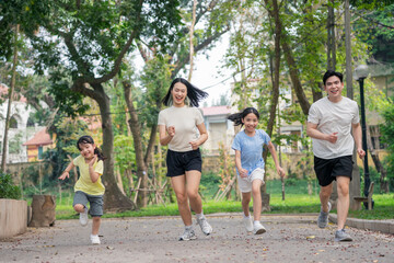 Obraz premium Group of children and adults enjoying a joyful run in a vibrant park on a sunny day