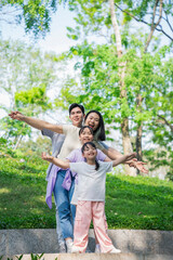 Fototapeta premium Family enjoying a joyful moment outdoors in a green park setting on a sunny day