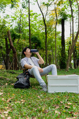 Fototapeta premium Relaxing in nature while enjoying a drink during a sunny day in the park