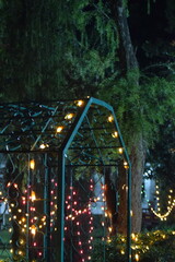 lighting on tree at night, Night theme garden decoration with tree decorated with light bulb, Wedding ceremony evening with candles and lamps in the coniferous pine forest