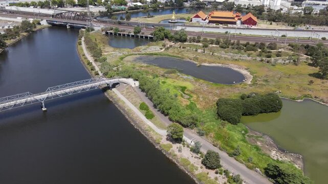 Aerial drone above river and nature reserve, panning down on a sunny day