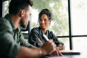 Group of young multi-ethnic startup business team collaborating on project in modern office