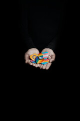 man holds some badges with different LGBTQ flags