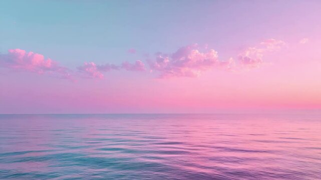 Calm ocean water under pastel pink and purple sky with soft clouds at sunset horizon