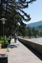 Man walks along the embankment along the Kura river in the city of Borjomi, Georgia