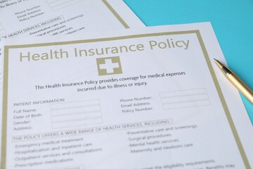 Fototapeta premium Health insurance policy forms and pen on light blue background, above view