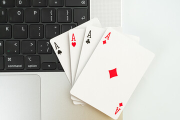A creative image showcasing playing cards on a laptop keyboard, suggesting themes of technology, digital gaming, strategy, online gamblinge-sports, and pressure decision-making