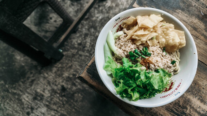 A bowl of Cwie mie complete with chicken, vegetables and fried dumplings