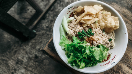 A bowl of Cwie mie complete with chicken, vegetables and fried dumplings