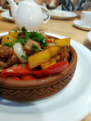Appetizing baked potato with vegetables in a clay plate in a Georgian restaurant, the concept of national local cuisine, Georgian dishes