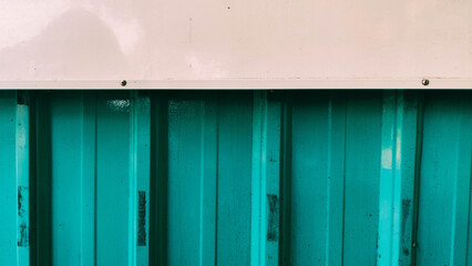 green metal wall with added white accents on top