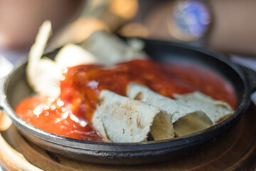 Mexican tortillas topped with hot sauce in selective focus restaurant, mexican national food concept