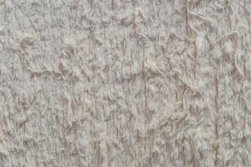 Close-up view of a textured, fluffy fabric with earthy colors tan, brown, diffuse lighting from upper right, product photograph style