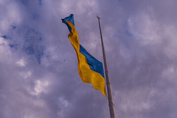 Yellow and blue flag on a pole, against an open sky backdrop Soft glow lighting from sunrisesunset...