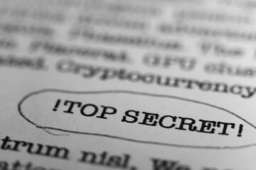 TOP SECRET. Text printed on a page. A piece of paper with a phrase written in retro typewriter font. Classified document