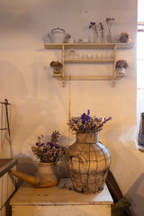 Dried flowers decorating rustic kitchen with vintage vases and shelf