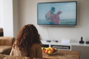 Person enjoys a cozy afternoon watching a scenic travel show featuring adventurous couple on a...