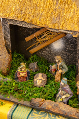 Nativity scene representing the birth of Jesus with Mary and Joseph praying under a thatched roof