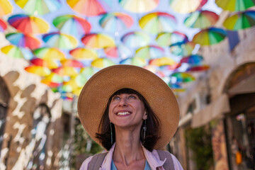 Happy female traveler sightseeing in historical city. umbrella sky.
