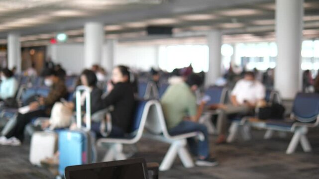 Blurred background of people waiting at airport terminal with luggage, travel and transportation atmosphere