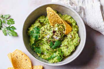 Avocado guacamole spread with nacho corn chips.