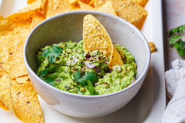 Avocado guacamole spread with nacho corn chips.