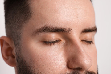 Man before eyebrows correction on light background, closeup