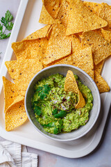 Avocado guacamole spread with nacho corn chips.