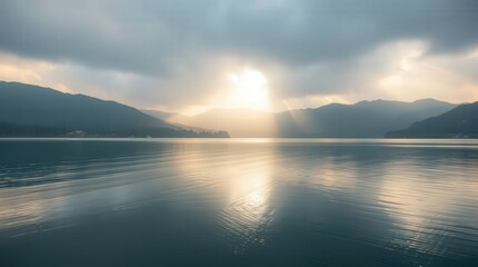 Fototapeta premium Serene Sunset Over a Tranquil Lake With Distant Hills and Clouds