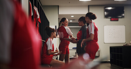 Team, soccer and women in locker room with coach, preparation for match or break with talking and...