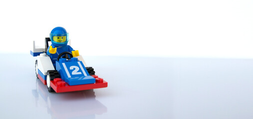 Obraz premium Coche de carreras azul y piloto al volante de LEGO oficial. Imagen aislada 