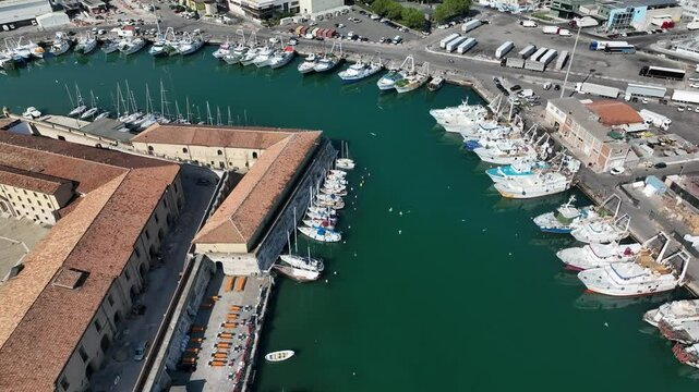 Aerial 4K video of the busy Ancona marina filled with sailboats, motorboats, and cruise ships. Beautiful coastal scene and port infrastructure.