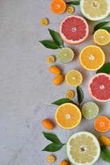 Arrangement of sliced citrus fruits such as orange, grapefruit, lemon, lime and kumquat on concrete...