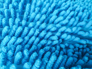 Abstract closeup of a textured blue microfiber cloth or mat. Soft, absorbent material for cleaning, bath, or home decor. Illustrates comfort, hygiene, and cleanliness.