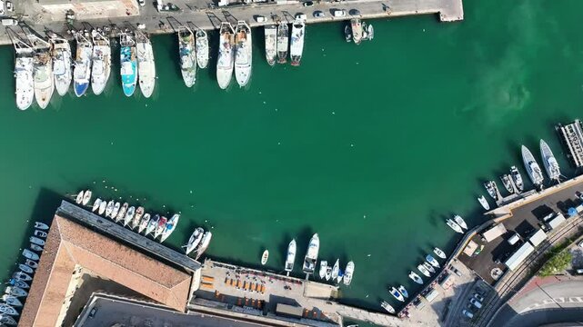 Scenic drone video of Ancona's cruise port filled with boats and yachts. Clear blue sea, busy docks, and the charm of Italian coastal life.