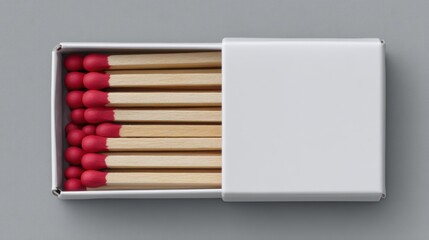 Open matchbox with matches inside on a gray surface.