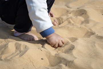 innocent kid hand exploring desert sand with hand from flat perspective