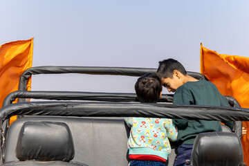 brothers sharing moment at vehicle during off road trip at day
