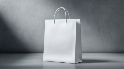 White paper shopping bag stands on a surface against a gray wall.
