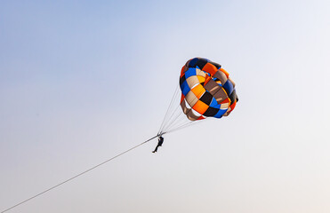 parasailing adventure activity at desert with bright blue sky background at day from flat angle