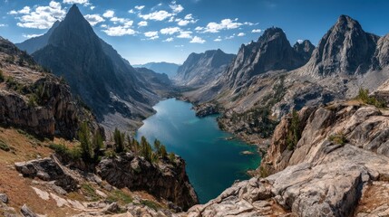 Scenic mountain lake surrounded by rocky peaks and trees under a blue sky.