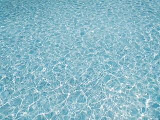 Serene, turquoise water shimmers under sunlight.  Perfect for backgrounds, website headers, or travel brochures, this image evokes calmness and tranquility.