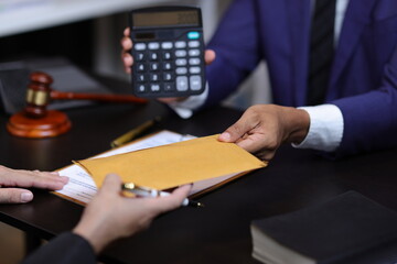 Lawyers discussing legal fees using calculator in law office. Two lawyers are discussing legal fees...