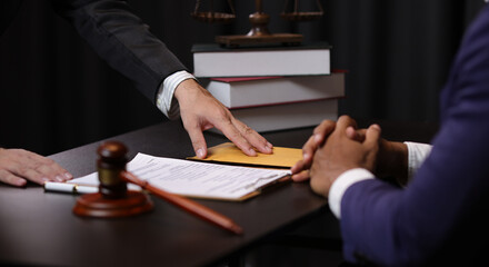 Lawyer receiving envelope with money for bribery. Corrupt lawyer receiving a bribe in an office,...