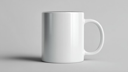 Obraz premium White ceramic mug with handle on a white surface casting a shadow.
