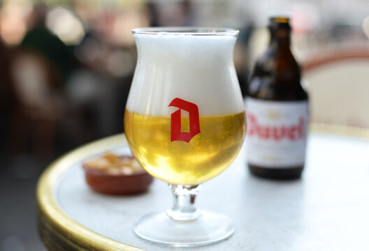 ANTWERP, BELGIUM &ndash; MAY 1, 2025: Glass of the Belgian traditional blonde Duvel beer with nice foam head and bottle in the back. Selective focus
