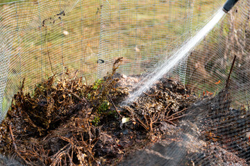 female farmer turning a compost pile in a community garden. compost full of microorganisms. sustainable regenerative agriculture with a soil sample in australia