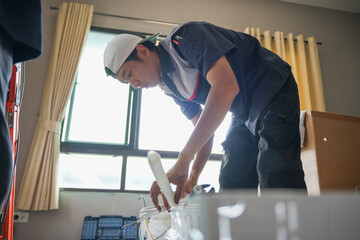 Fototapeta premium Air conditioning technician man install new air conditioners in homes, Repairman fix air conditioning systems, Worker service for repair and maintenance of air conditioners