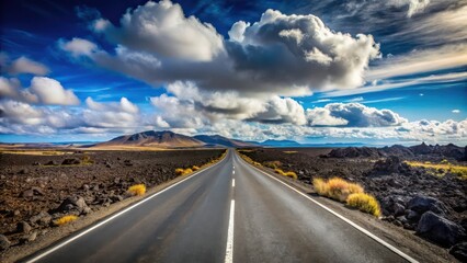 Asphalt ribbon cutting through a volcanic landscape under a dramatic sky, promising adventure and open horizons