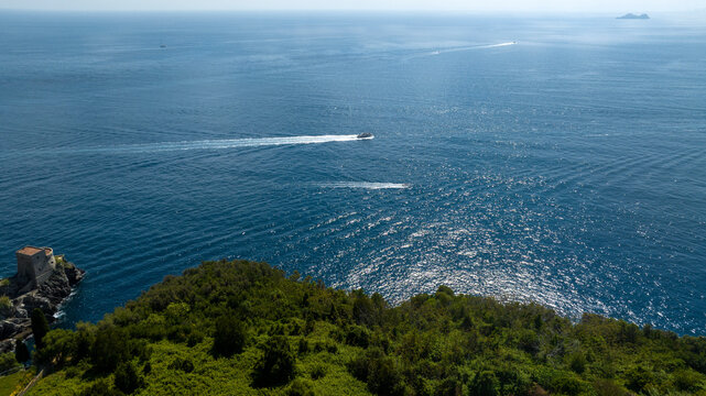 Aerial view of a boat crossing the blue sea in Amalfi Coast, province of Salerno, Italy. In the background is the Mediterranean Sea. - Powered by Adobe